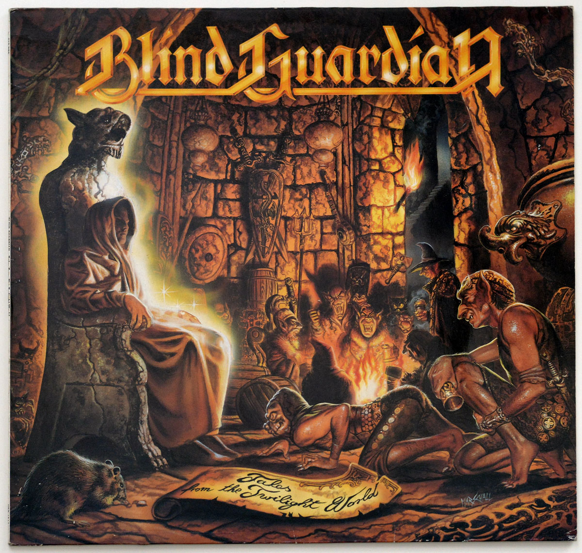Blind Guardian's 'Tales from the Twilight World' album cover: a dark, medieval chamber where a hooded figure sits on a throne beside a monstrous statue. Around a fire, sinister characters—dwarves, orcs, and a wizard—gather, surrounded by relics, skulls, and ancient carvings.